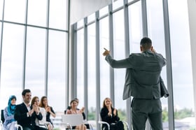 a businessman presenting to an engaged audience, showcasing professional insights and ideas in a conference setting